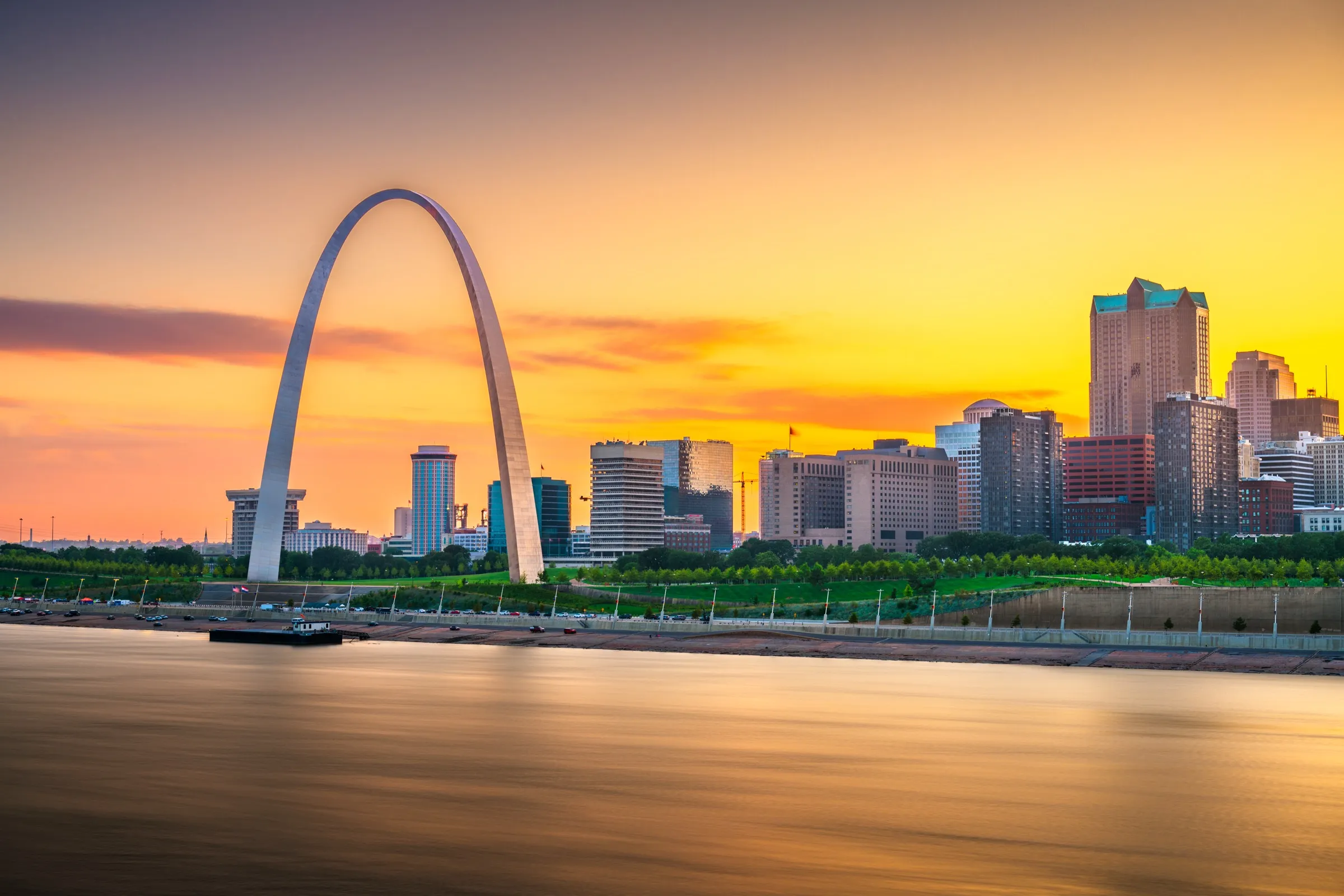 Downtown St. Louis skyline and Gateway Arch at sunset along the Mississippi River